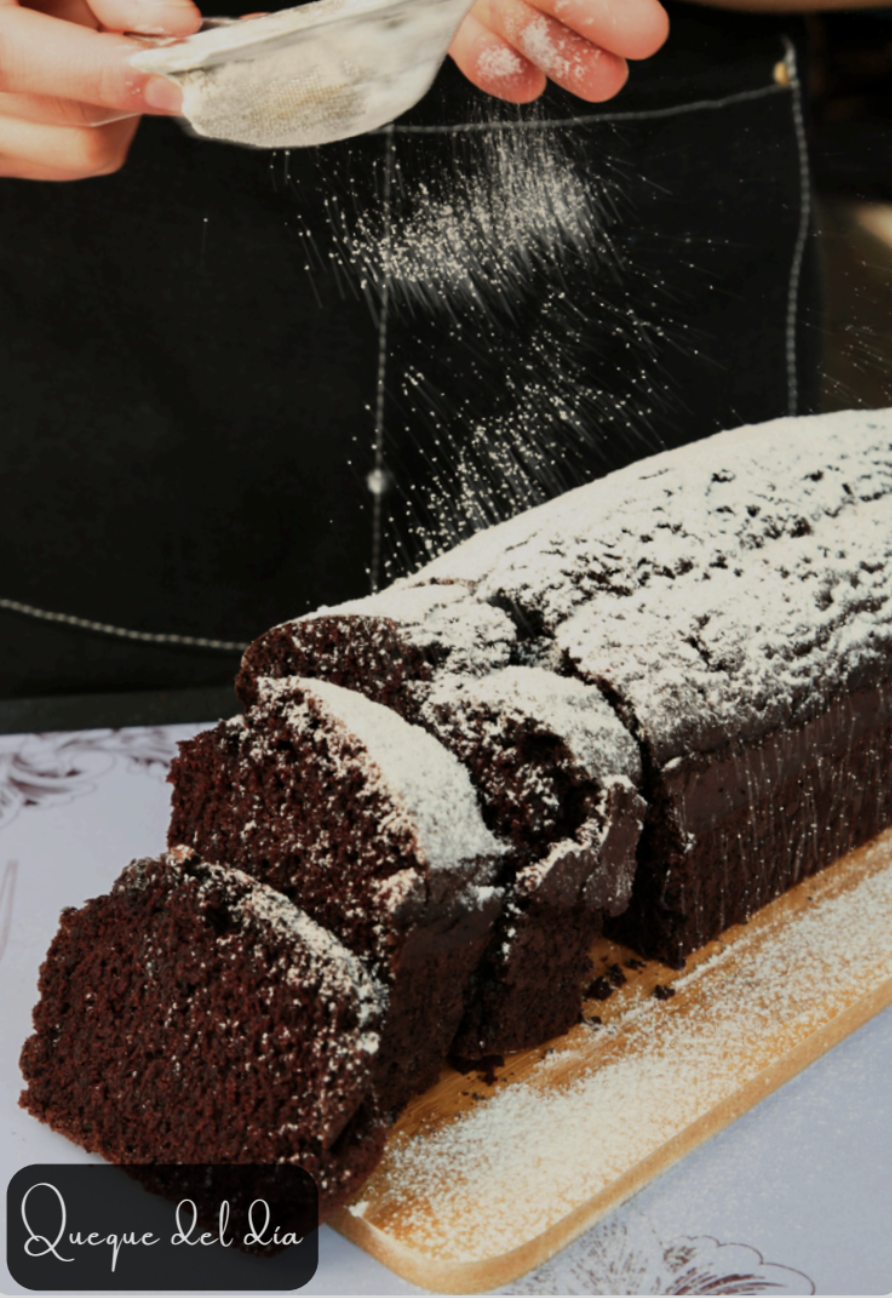Chocolate cake being dusted with powdered sugar